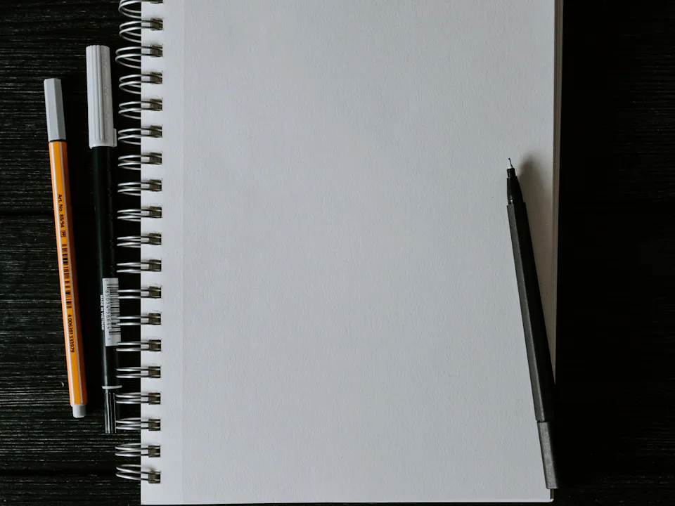 Cuaderno de anillas cerrado con un bolígrafo encima sobre fondo claro