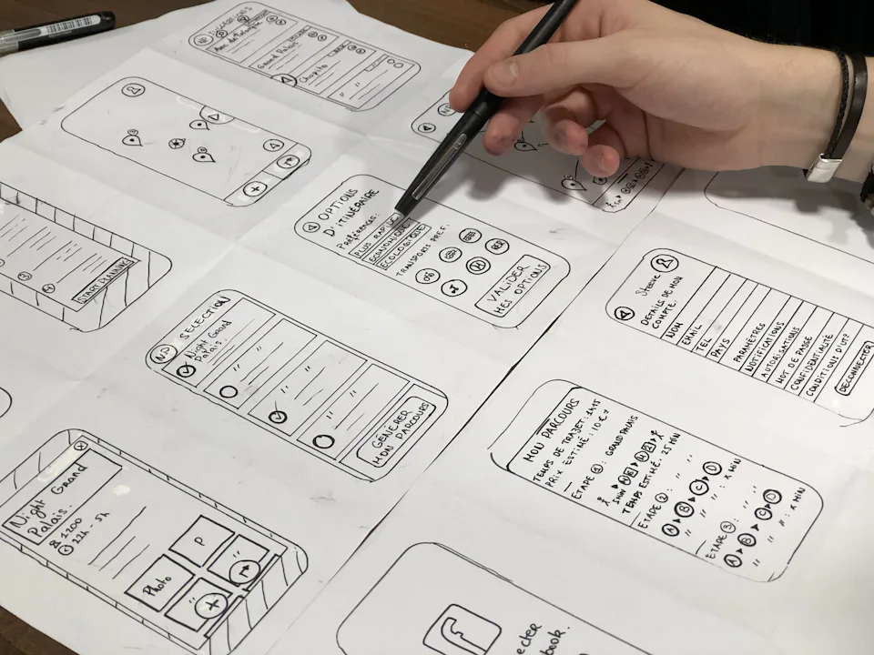 Mano dibujando el esquema de una interfaz sobre papel